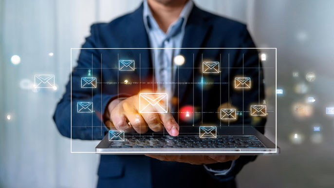 A businessperson pressing a digital "Send" button on a laptop, with multiple email icons floating around, symbolizing the automation of customer follow-ups through scheduled and consistent email communication.